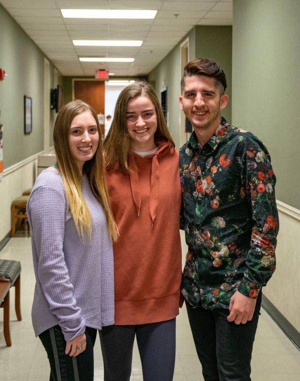Three city year students pose in the hallway in the college of education