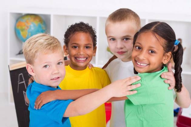 Four children hugging and smiling