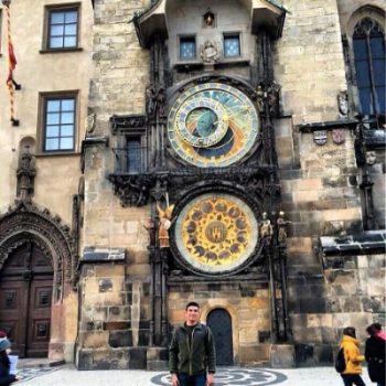Man standing in front of a large clock.
