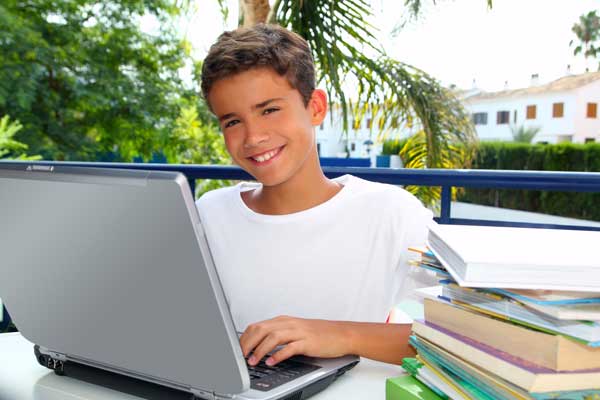 Elementary student with a laptop and textbooks