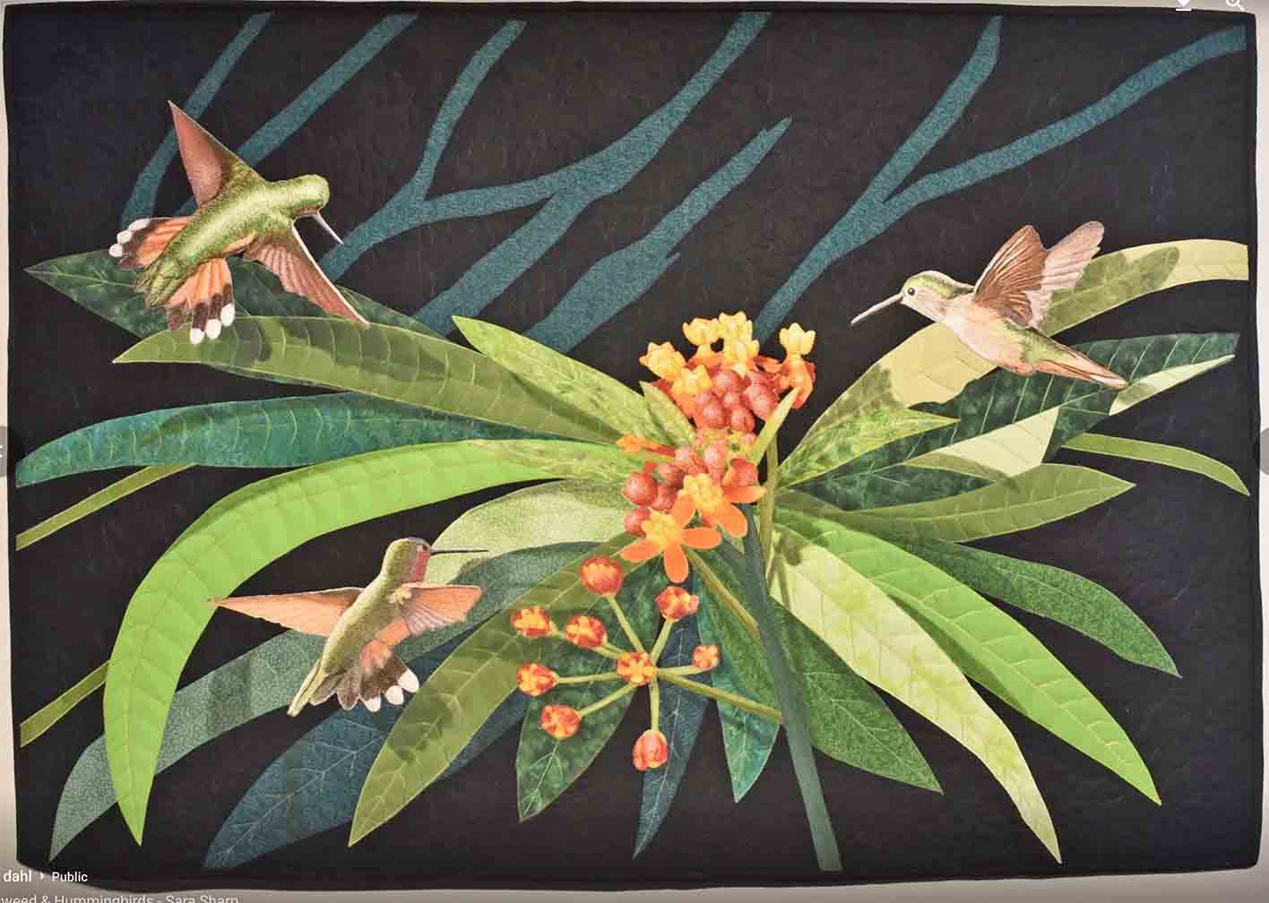 art quilt in horizontal orientation with image of a milkweed plant and hummingbirds