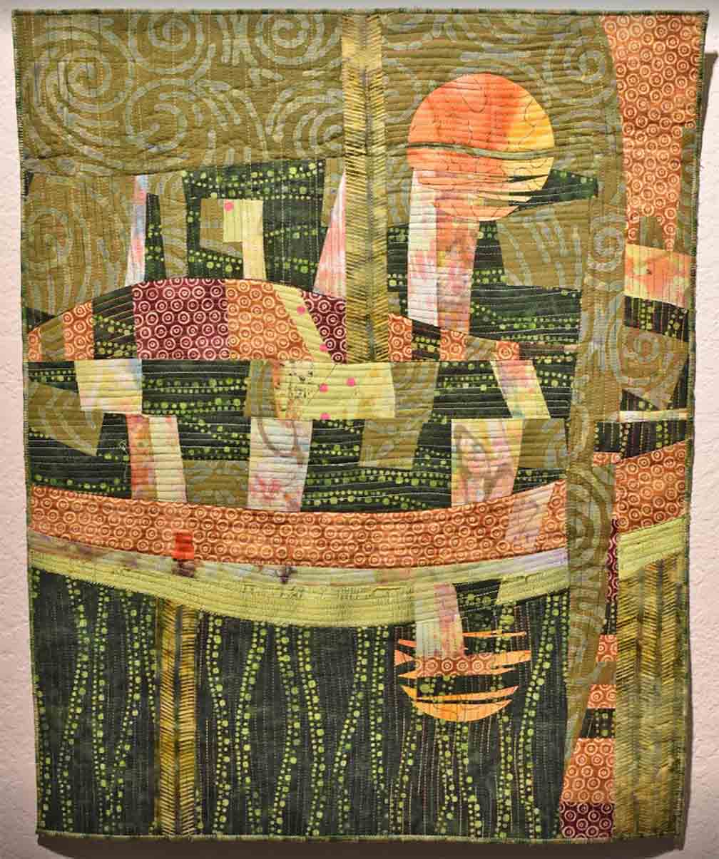 Art quilt in vertical orientation in the colors of olive, sage green peach and soft yellow
