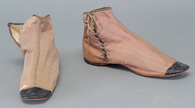 Adult’s Beige Fabric Flats with Black Leather Trim on Toes, two left shoes not a pair, c 1830-40s, Gift of L. Jean and Rebecca Wallace, TTU-          H2017-030-045