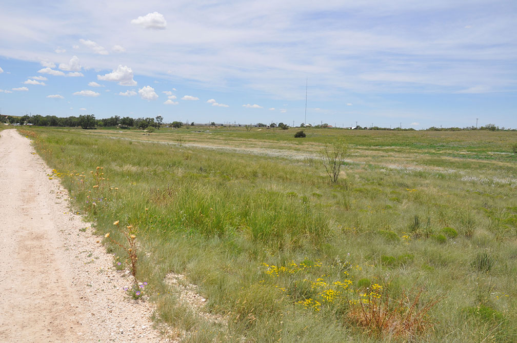 landscape view of the Landmark showing a dirt road and field