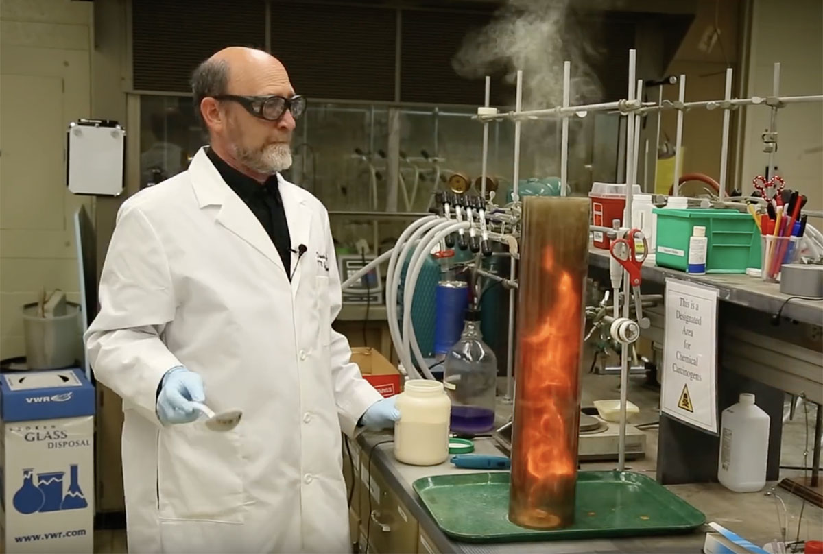 professor makes chemical reaction that produces fire in large beaker