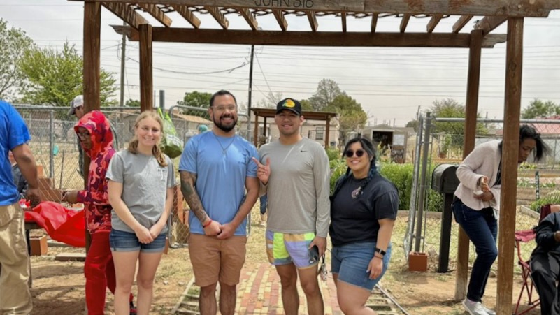 student organization members pose for picture at community garden for Earth Day 2023