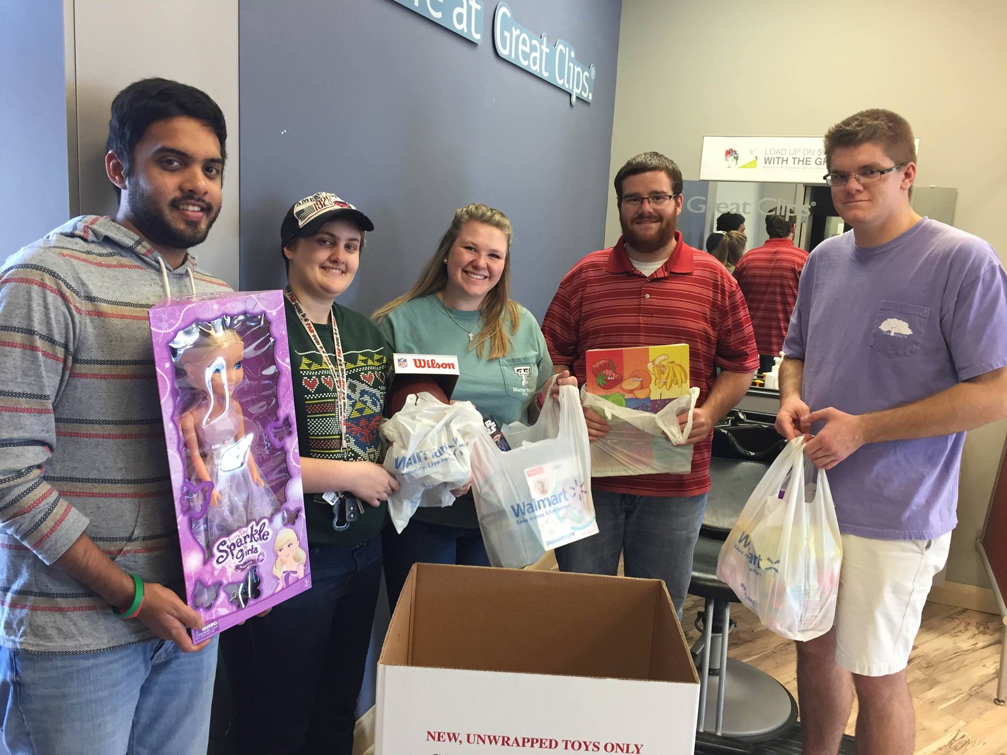 Tutors holding up bags of toy donations