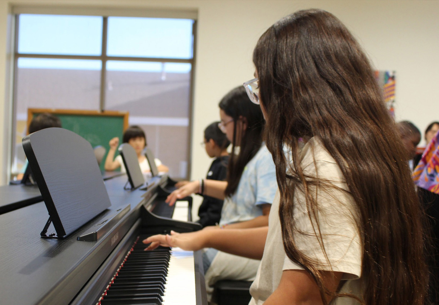 Students playing piano in their classroom at the Guadalupe Center in Lubbock