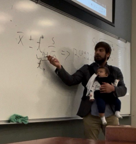 Thomas teaching with child in arms