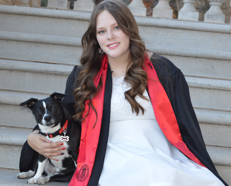 Woman in grad gown with dog