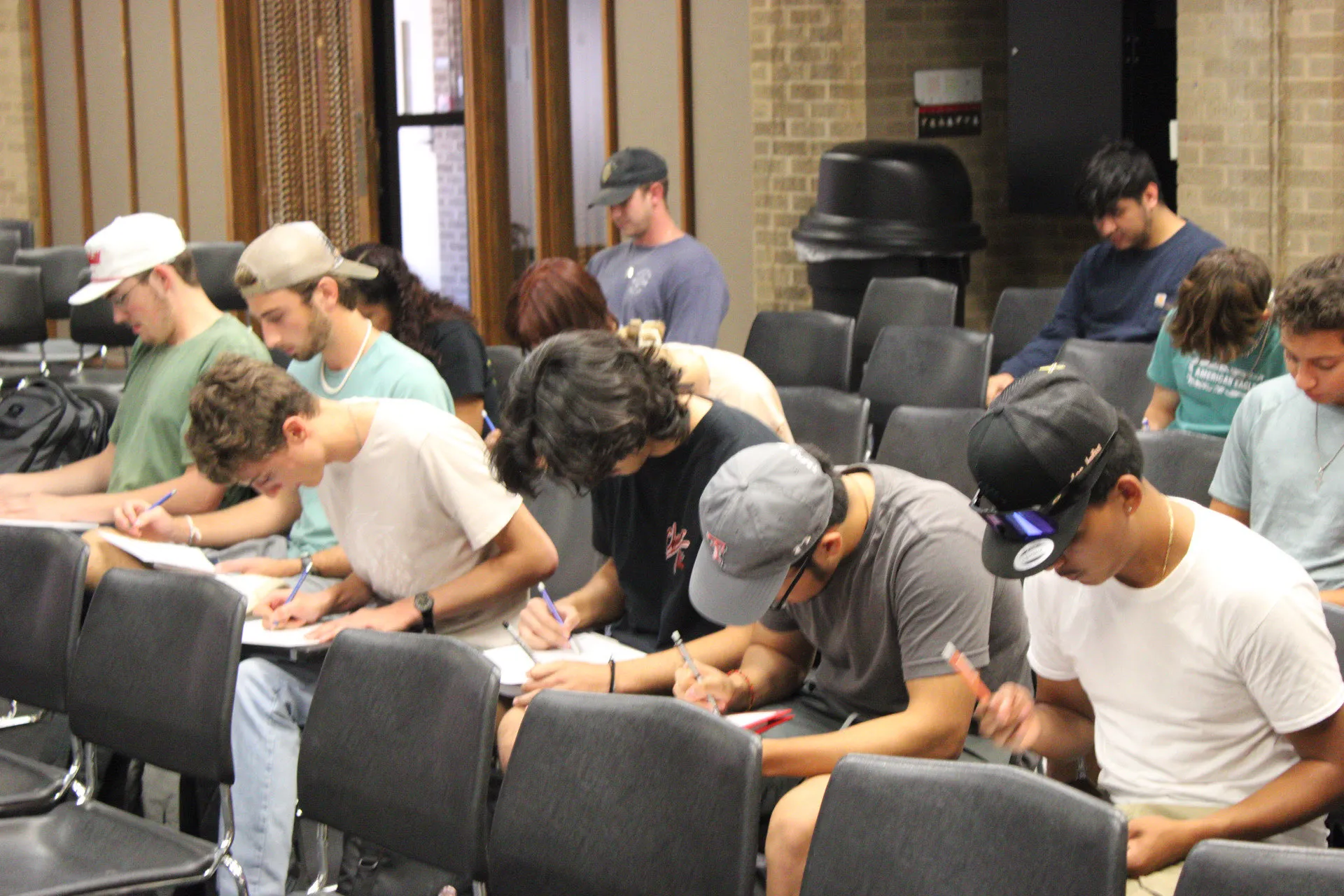 A row of Studio Hacks students writing in notebooks.