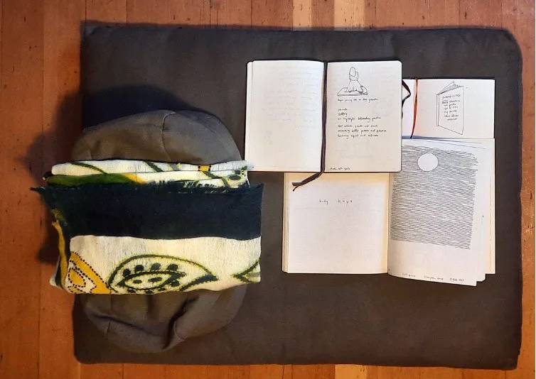 A picture of meditation cushions and journals.