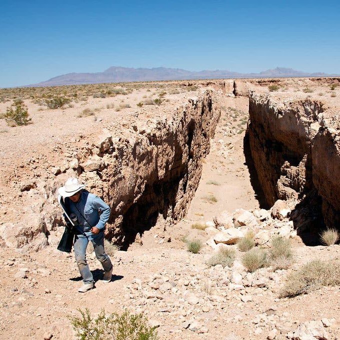 Photographer finishing walking through a large trench.