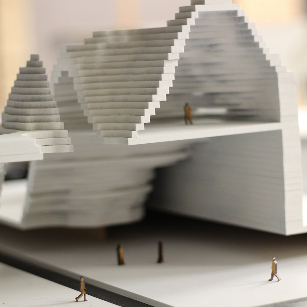 Layered cutout of structure with small people models.