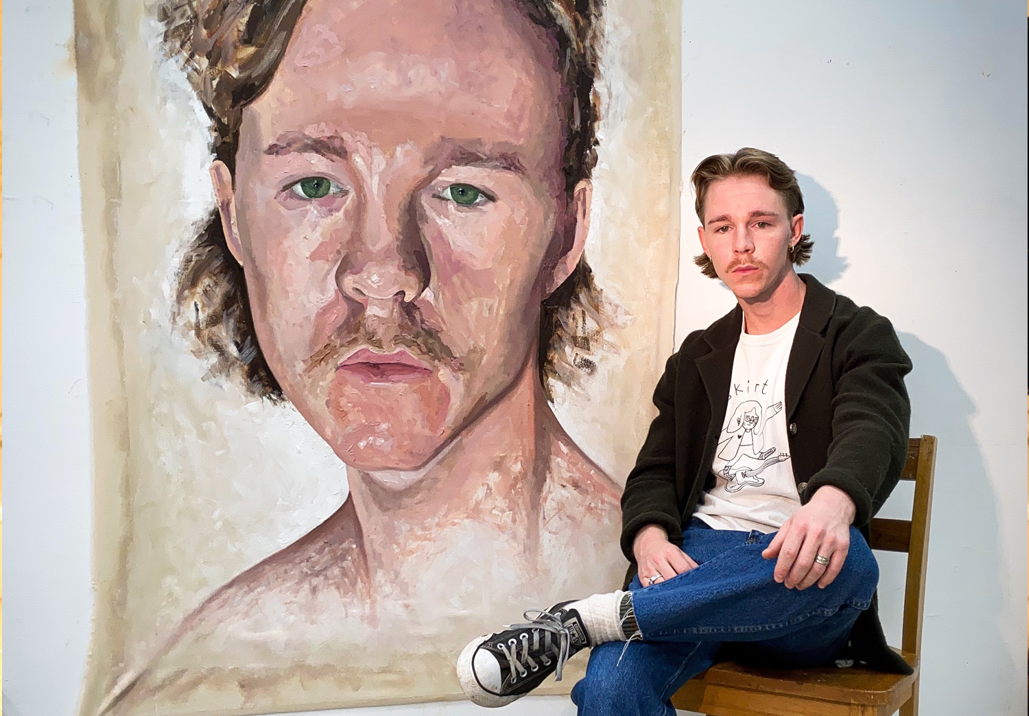 Holden Sutton sitting in front of his portrait