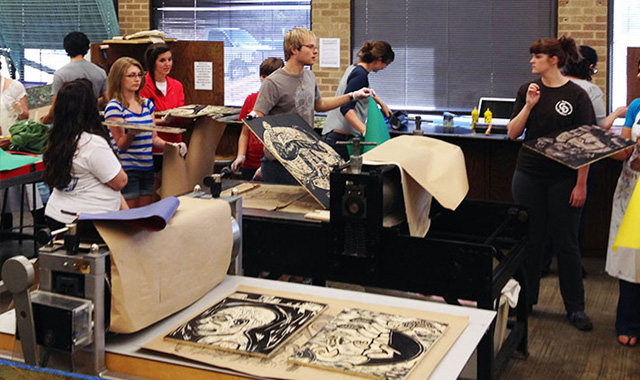 Student working printmaking equipment