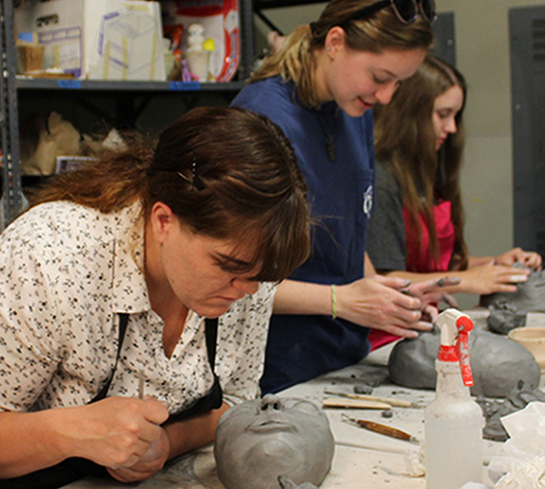Faculty and students working with clay