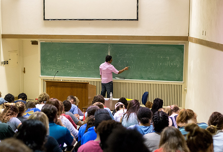 professor writing on a chalkboard