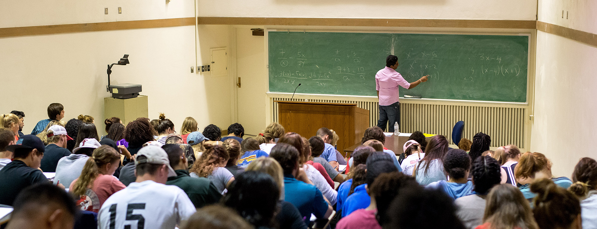 professor writing on chalkboard