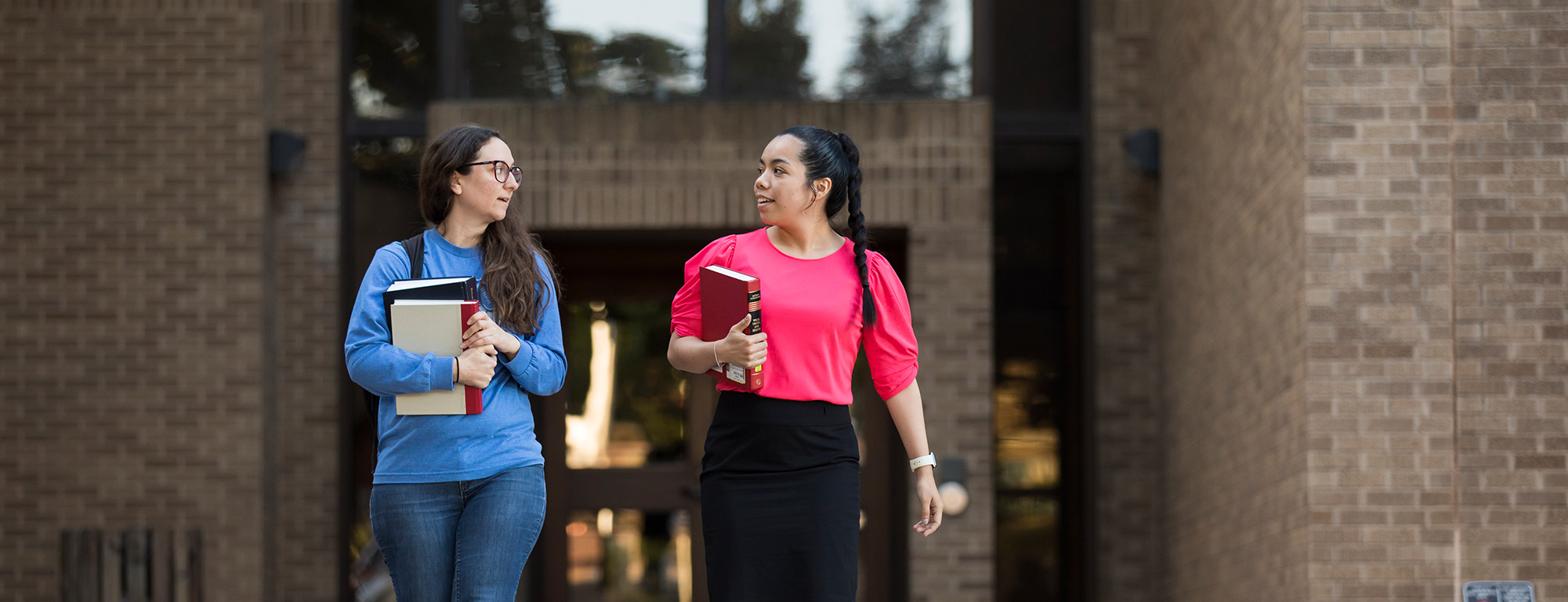 students walking holding books