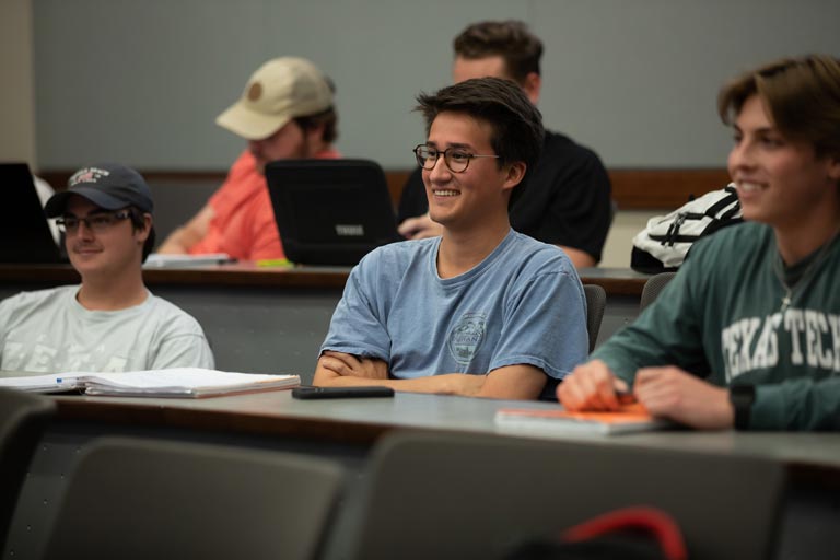 Group of student in a classroom listening intently to their professor