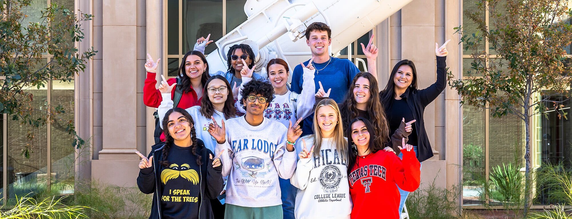 Texas Tech college of arts and sciences students in front of the academic sciences building's telescope
