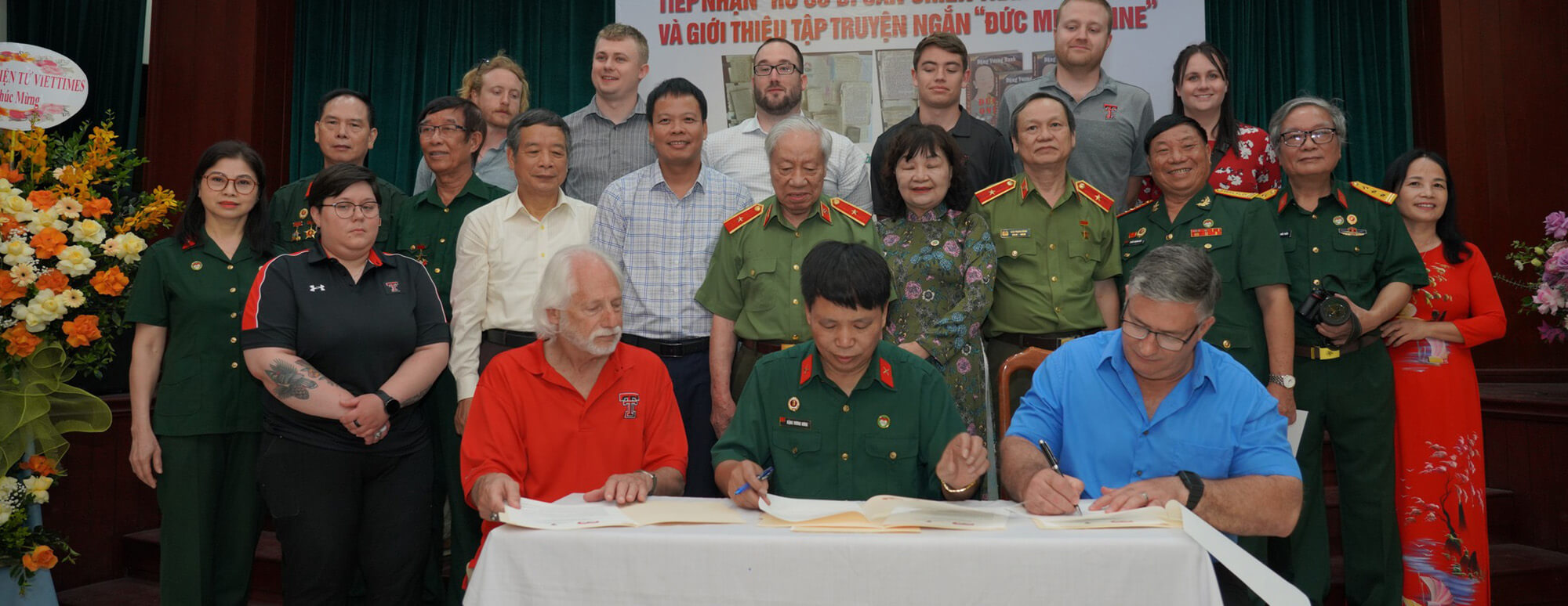 Returning Legacy Item Ceremony - Ron and Steve at table, Texas Tech students on back row