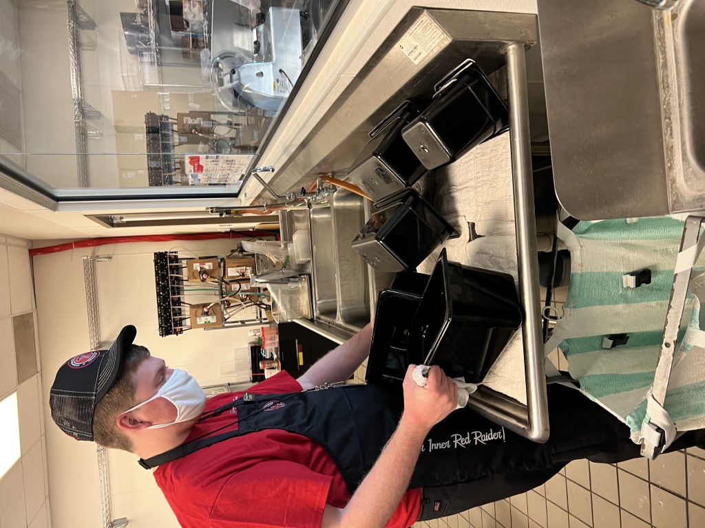 Student preparing food in a commercial kitchen