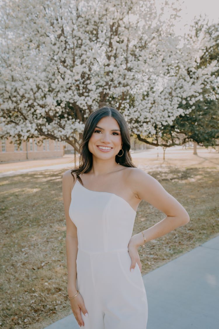 Woman wearing wrhite dress in front of tree