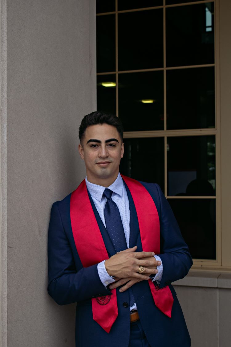 Man wearing suit and Texas Tech graduation stole