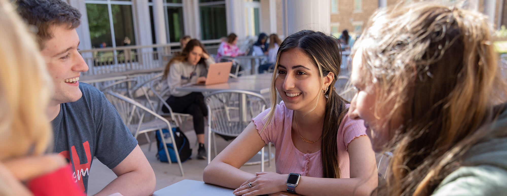 group of Texas Tech students sitting outside at a table and talking