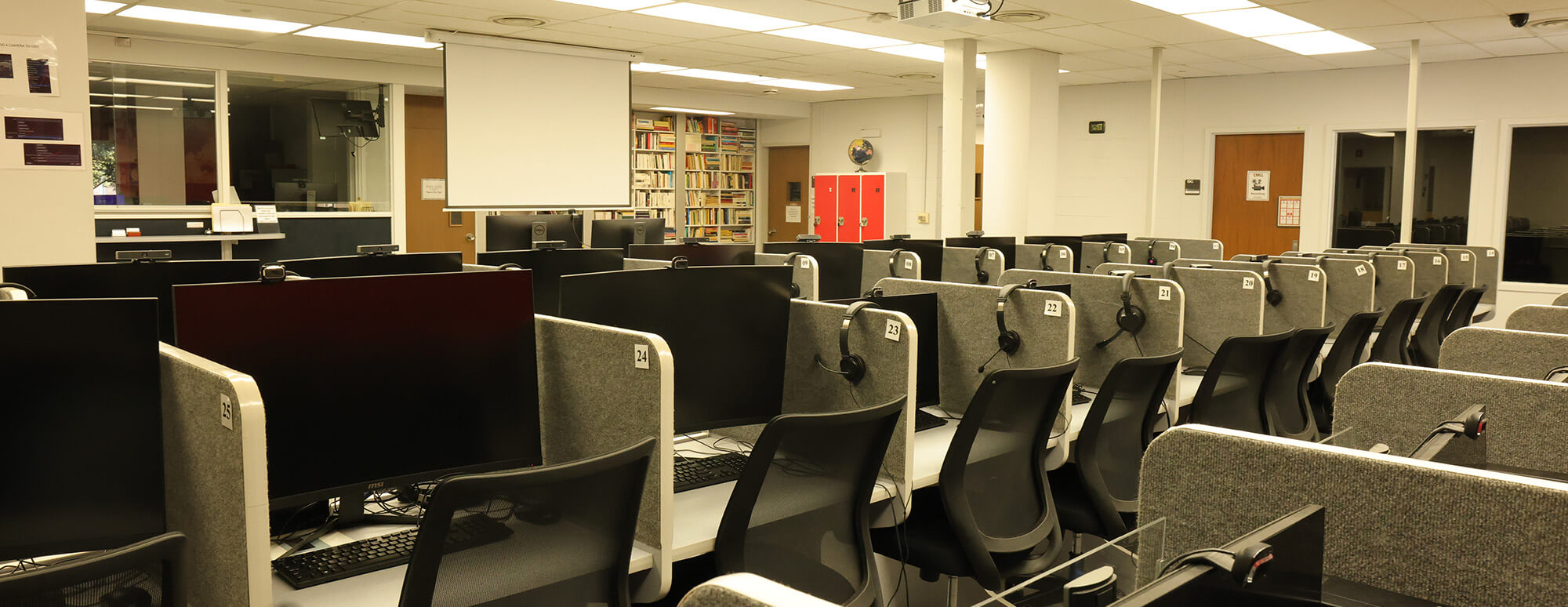 multiple desks with headphones within the language lab and research center