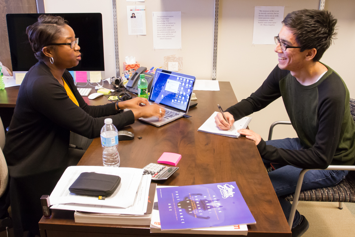 Erica Taylor talking to a student at her desk