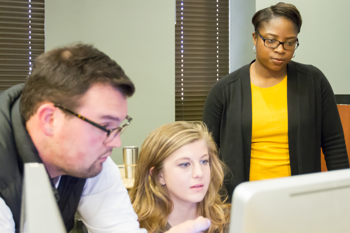 Erica Taylor and students looking at a production