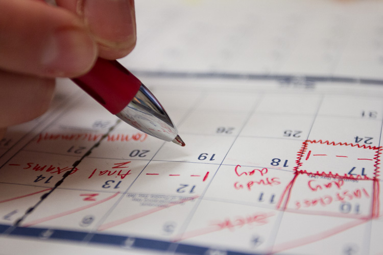 Close up of a red pen while writing on a calendar