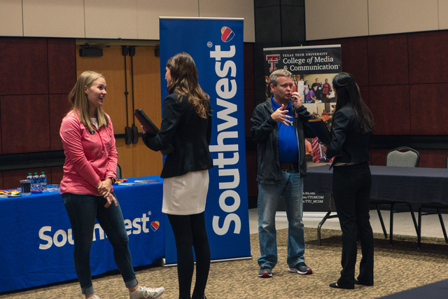 People having a conversation in front of a Southwest Airlines table