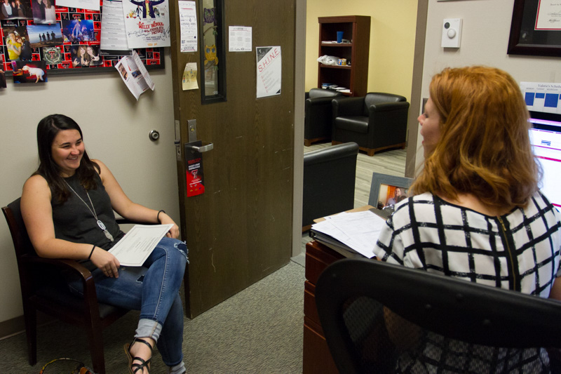 Debra sitting and talking with a student