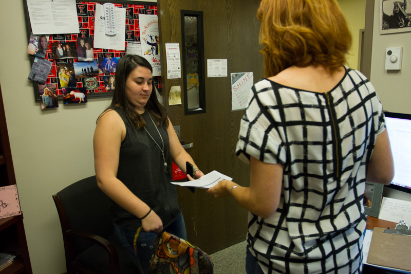 Debra handing a student a sheet with their classes