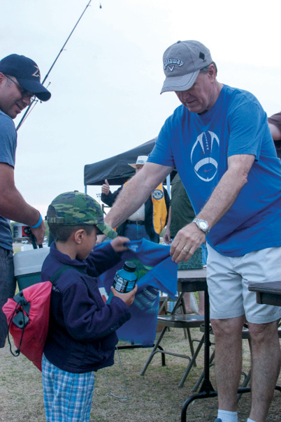 Kid getting his fishing tournament t-shirt