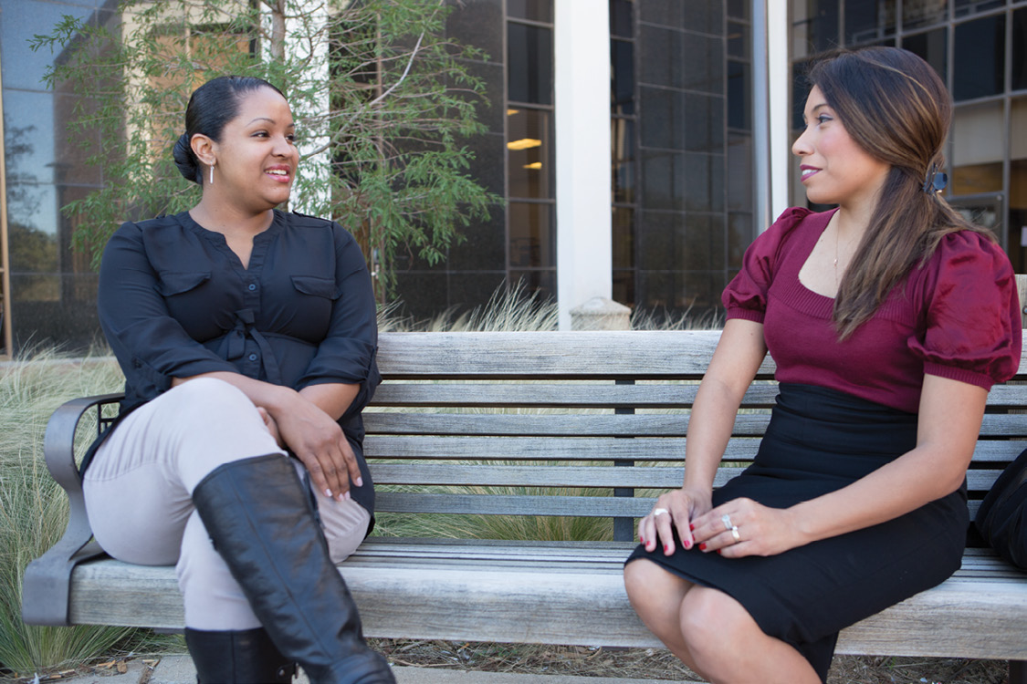 Sasha Wilson and Lucinda Holt talking on a bench