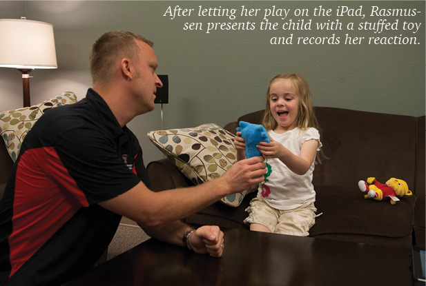 Dr. Rasmussen giving a child a stuffed animal to play with