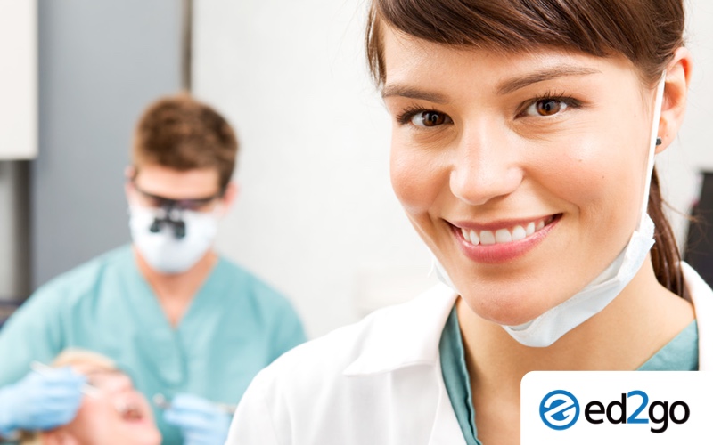 Photo of medical assistant smiling while dentist works with patient