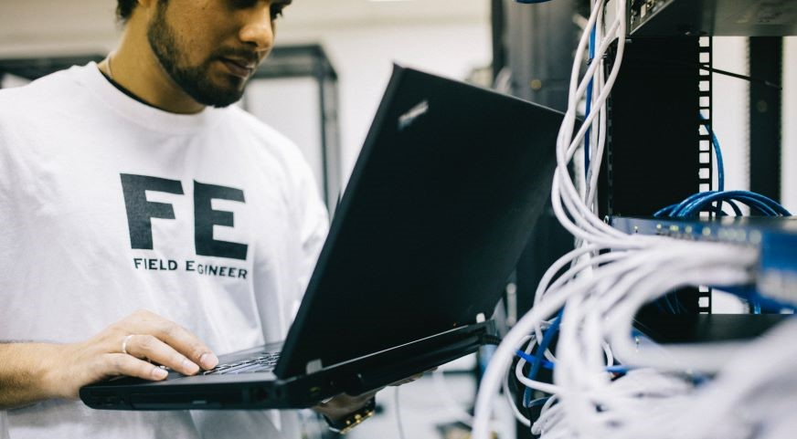 a young engineer with computer and cables