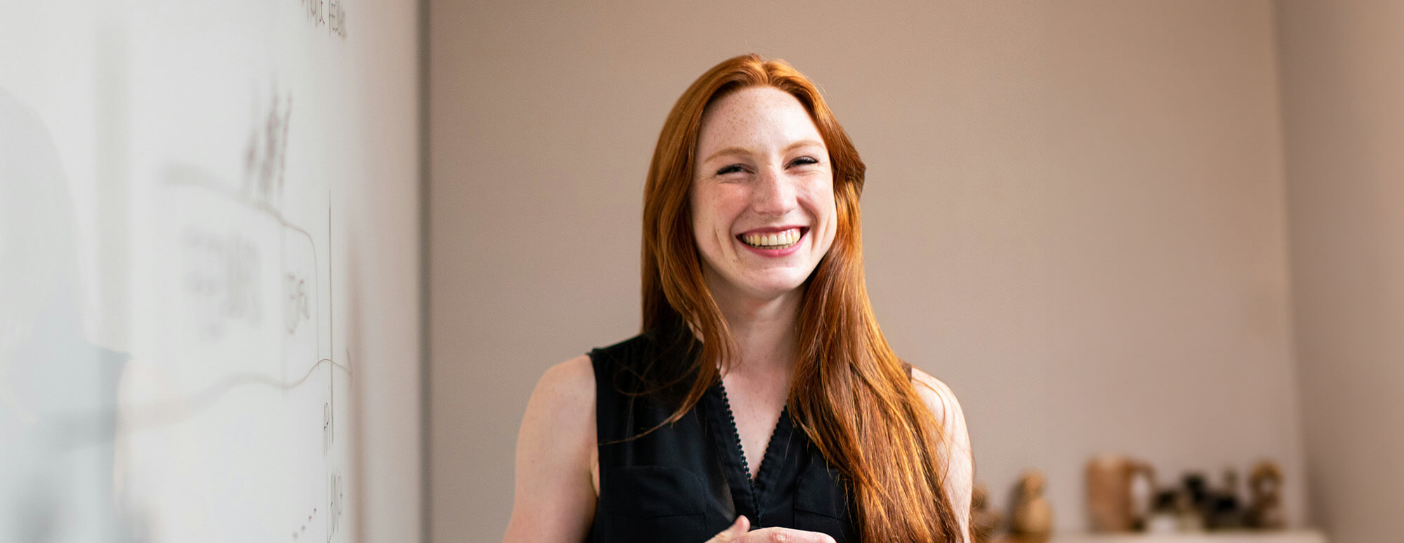 student smiling in front of a dry erase board