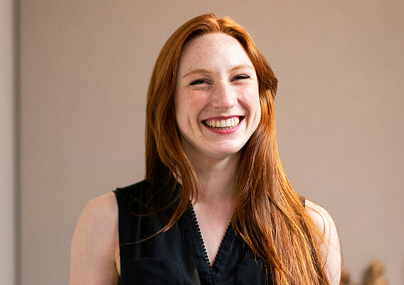 student smiling in front of a dry erase board