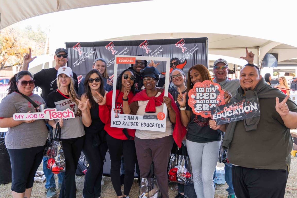 Group of educators posing giving the Guns Up hand sign