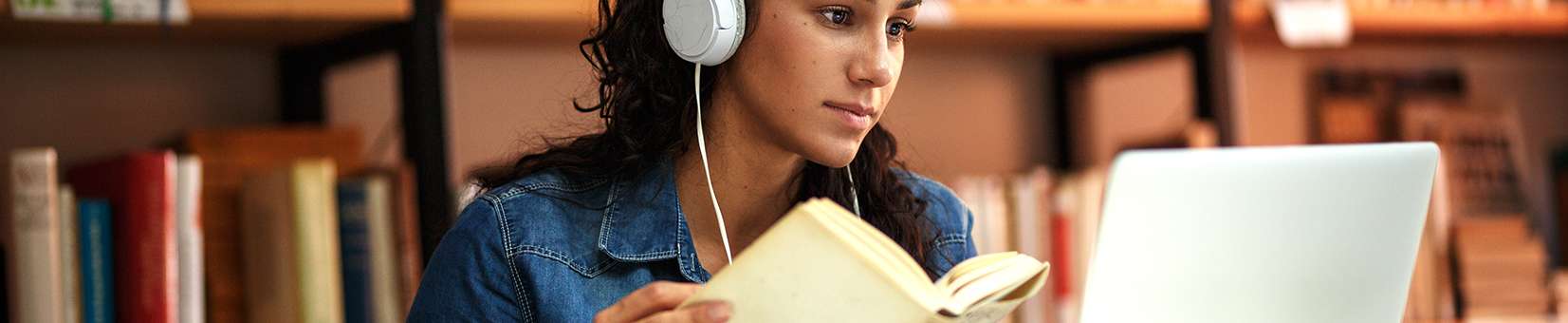 Photo of a student in headphones studying on a laptop
