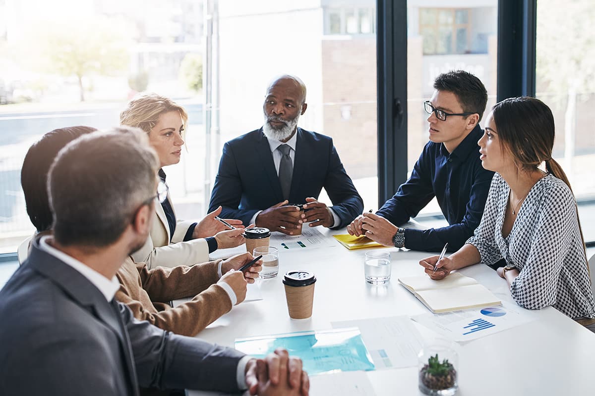 Group of administrators in business attire around a conference table