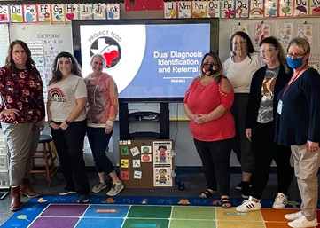 Group photo of teacher trainers from Project TEDD standing in a K-12 classroom.