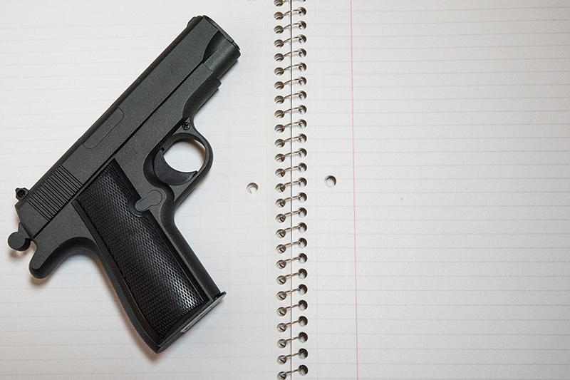 Hand gun on school notebook